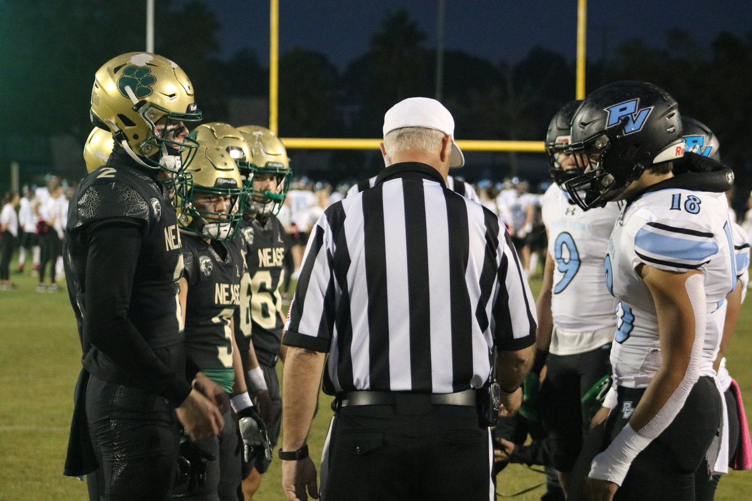 Captains for both teams meet at midfield for the coin toss prior to the showdown.
